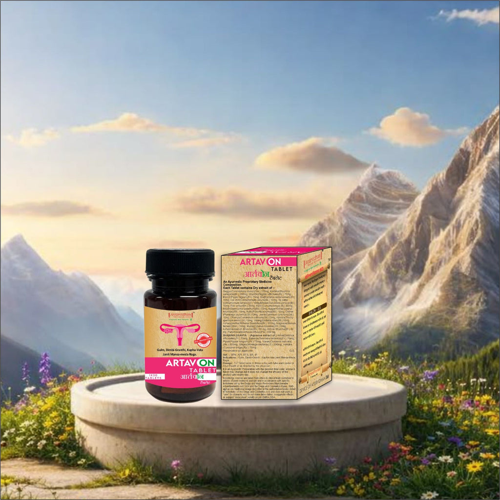 A small amber supplement bottle with a black cap and a matching product box labeled ARTAYON VITAL, placed on a stone pedestal in front of a scenic mountain landscape with flowers and a blue sky.