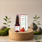 A bottle of Asharodas Vitorist LP Syrup and its packaging box displayed on a round wooden pedestal, with decorative plants and moss in the background.